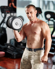 Fototapeta na wymiar Man doing biceps curl in gym