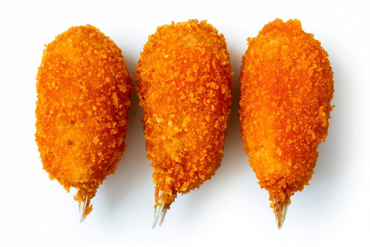 Three fried breaded surimi crab claws from above, isolated on wh