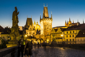 charles bridge with tower and people by night