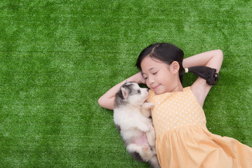 Cute asian girl lying with her puppy
