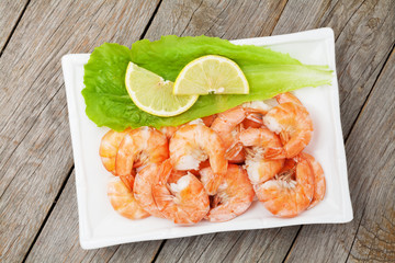 Cooked shrimps with lemon and salad leaves
