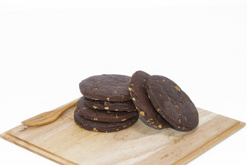 Stacked chocolate chip cookies on wood tray in background