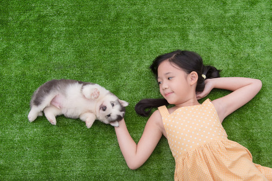 Cute asian girl lying with her puppy
