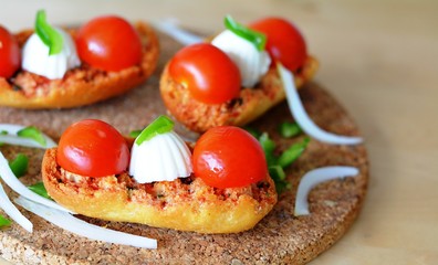 Italian Bruschetta With Mozzarella And Tomato On A Wooden Table