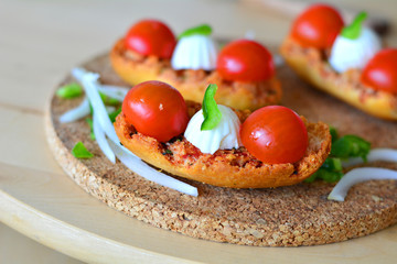 Italian Bruschetta With Mozzarella And Tomato On A Wooden Table