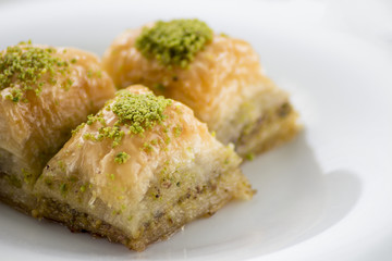 Baklava with pistachios and walnuts on white plate. Shallow depth of field
