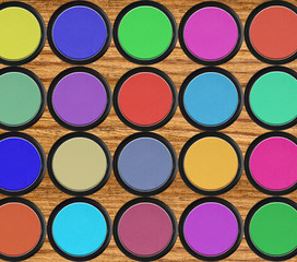 colorful eyeshadows in black boxes over wooden table