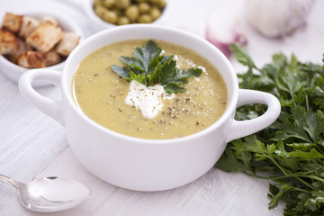 A delicious pea cream with aromatic spices on a wooden table.