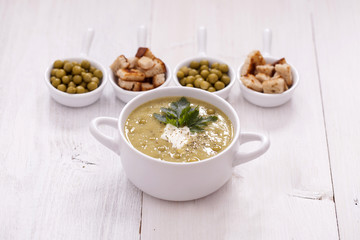 A delicious pea cream with aromatic spices on a wooden table.