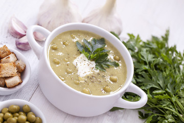 A delicious pea cream with aromatic spices on a wooden table.