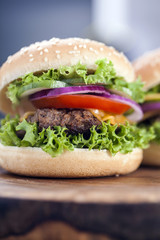 Beef burgers on a wooden board with aromatic spices