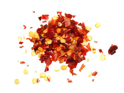 pile crushed red pepper, dried chili flakes and seeds isolated on white background