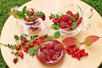 Vitamin tea from assorted red berries on wooden background
