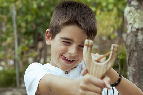 boy with slingshot outdoors