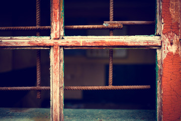 Rusty iron grid instead of window on a grunge background