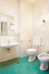 Fototapeta na wymiar Simple, old bathroom with green tiled floor