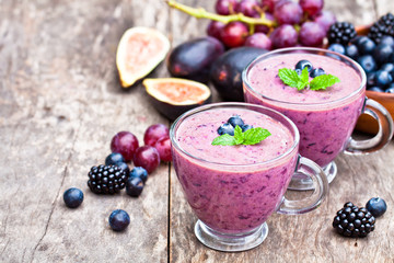 fresh healthy pulpy cocktail with purple fruits and berries