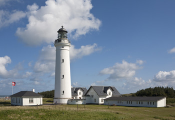 Fototapeta na wymiar Traditional Danish Lighthouse. A traditional and grand lighthouse standing proudly on a summer's day.