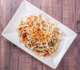 Malaysian dish bean sprout salad or local name Kerabu Taugeh in a white plate over wooden background