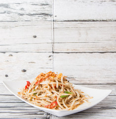 Malaysian dish bean sprout salad or local name Kerabu Taugeh in a white plate over wooden background