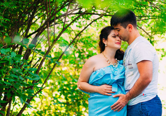 Beautiful pregnant couple relaxing outside in the park.