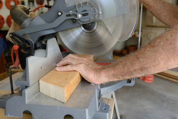 Builder Using Saw to Cut Wood in Shop