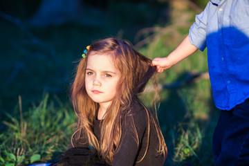 portrait of a beautiful little girl while her toddler brother is