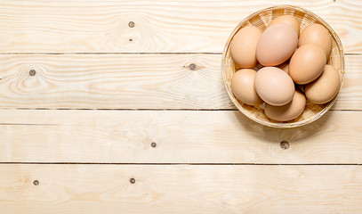Hen eggs in basket on table