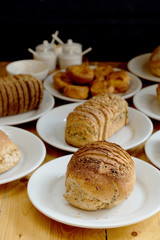 Baked bread on white plate and wooden table with Selective focus.