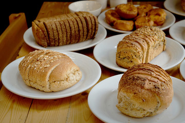 Baked bread on white plate and wooden table with Selective focus.