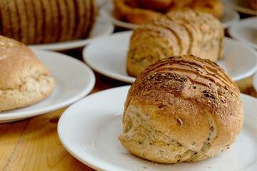 Baked bread on white plate and wooden table with Selective focus.