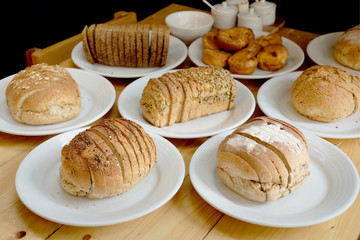 Baked bread on white plate and wooden table with Selective focus.