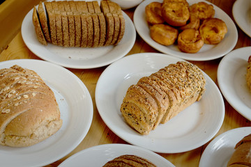 Baked bread on white plate and wooden table with Selective focus.