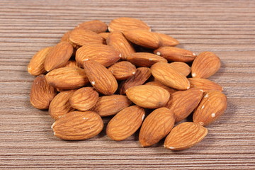Heap of almonds on wooden background