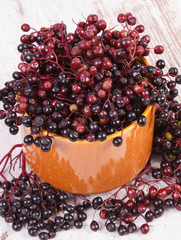 Bunch of fresh elderberry on old wooden background, healthy food