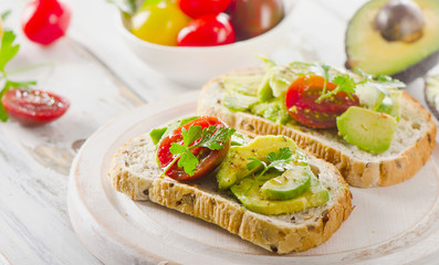 Homemade sandwiches with sliced avocado and tomato.