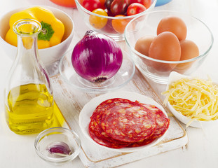 ngredients for baked eggs with vegetables, cheese  and chorizo.