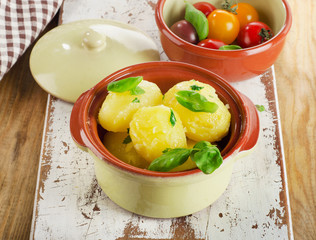 Boiled potatoes with fresh herbs in bowl.