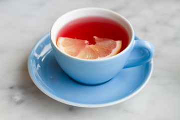 Red fruit tea with lemon slice in blue cup