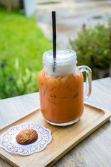 Iced milk Tea and cookie on wooden tray