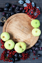 Old board, plums, viburnum, and apples background
