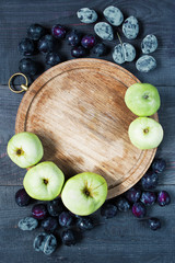 Old board, plums and apples background