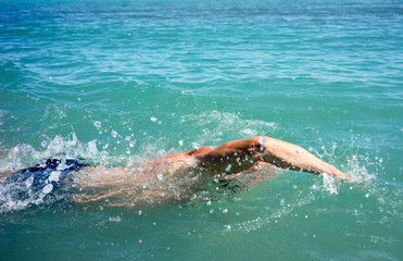 A man swims in the open sea