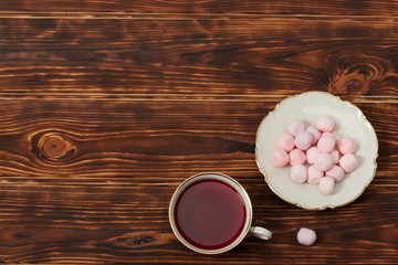 Tea Cup and Plate Of Fine Bone China. Sweets. Burnt Wooden Backg