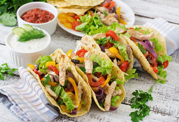 Mexican tacos with chicken, bell peppers, black beans and fresh vegetables.