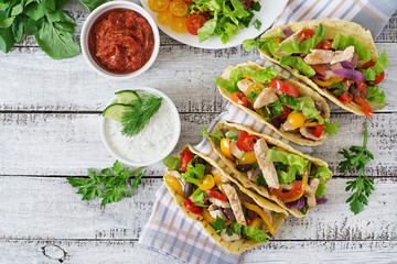 Mexican tacos with chicken, bell peppers, black beans and fresh vegetables.