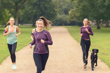 Hübsche Frau joggt im Park mit Freundinnen