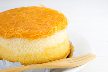 Gold egg yolks thread cake  on white wood background