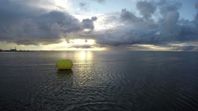 yellow buoy on early morning sea water near coastline and wind. Seascape, timelapse 4K