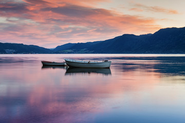 Fototapeta premium Two lonely boats on calm water of fjord. Norway.